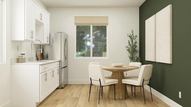 dining area featuring light wood-style floors and baseboards