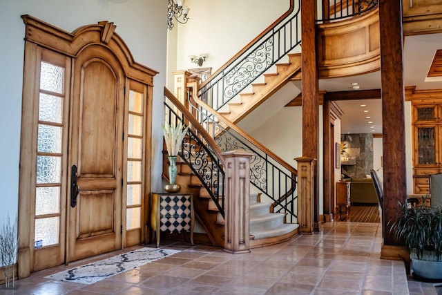 foyer entrance with stairs and a high ceiling