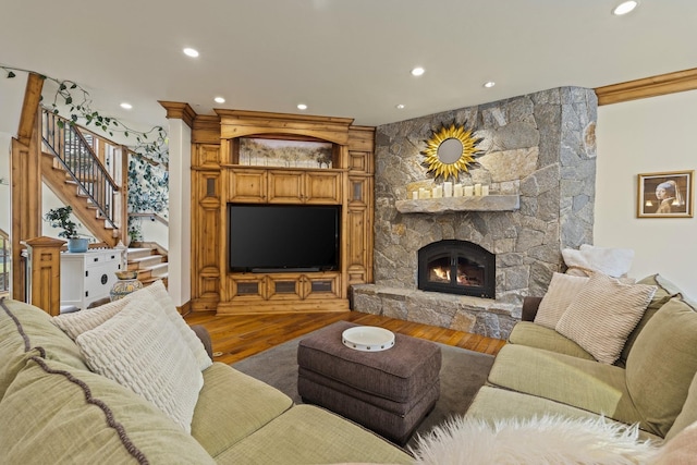 living room with recessed lighting, a fireplace, stairway, and wood finished floors