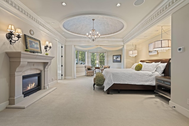 bedroom featuring baseboards, a raised ceiling, a glass covered fireplace, light colored carpet, and a notable chandelier