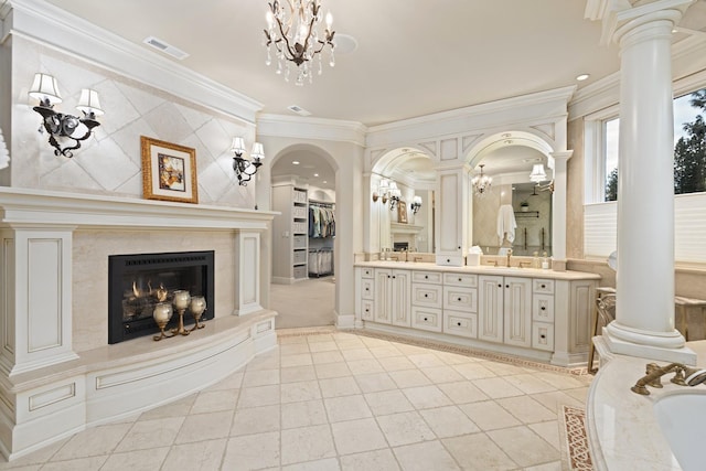 bathroom featuring ornamental molding, a fireplace, and decorative columns