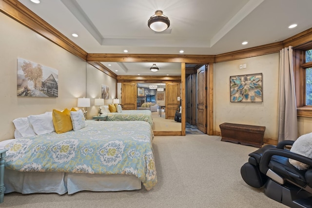 carpeted bedroom featuring recessed lighting, a raised ceiling, and crown molding