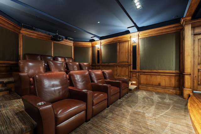 cinema featuring wooden walls, carpet, and a decorative wall