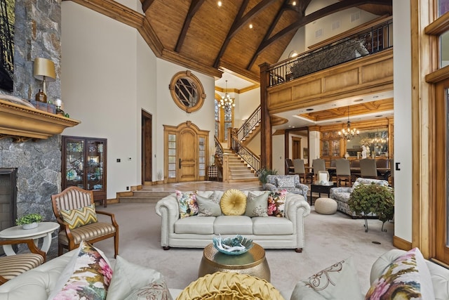 carpeted living room featuring high vaulted ceiling, stairway, a notable chandelier, and a stone fireplace