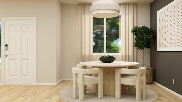 dining space with baseboards and wood finished floors