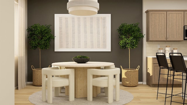 dining space featuring light wood-type flooring and baseboards