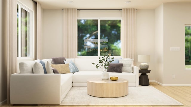 living area with light wood-type flooring and baseboards