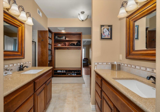 bathroom with tasteful backsplash, vanity, visible vents, and tile patterned floors