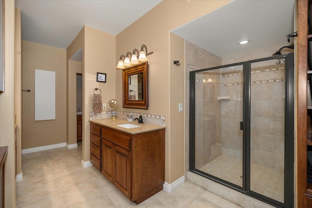 bathroom featuring baseboards, a stall shower, vanity, and tile patterned floors