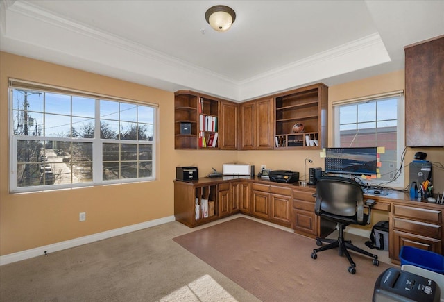 office featuring a healthy amount of sunlight, baseboards, built in desk, and light colored carpet