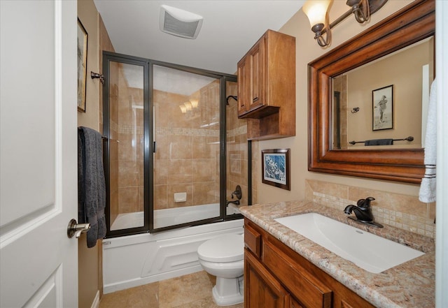 full bathroom featuring tasteful backsplash, toilet, tile patterned flooring, combined bath / shower with glass door, and vanity