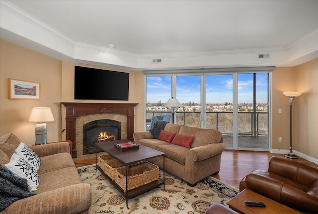 living room with crown molding, visible vents, and wood finished floors