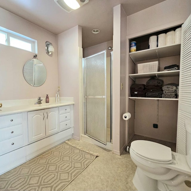 full bathroom featuring toilet, a stall shower, and vanity