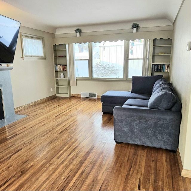 328 W Nebraska Ave, Spokane, WA 99205 - living room with wood finished floors, a fireplace with flush hearth, built in shelves, and baseboards