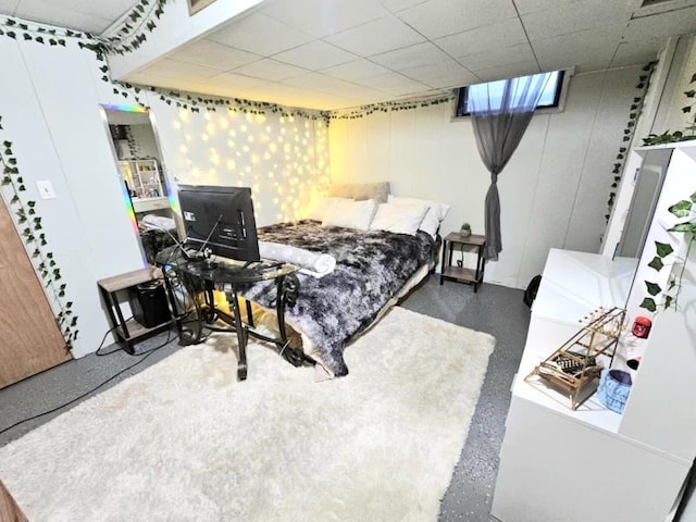 bedroom with a drop ceiling and speckled floor