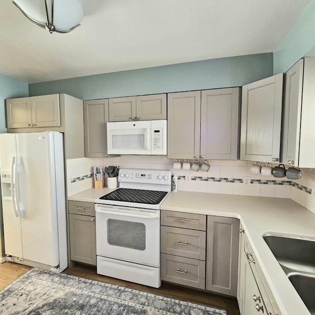 kitchen with gray cabinets, white appliances, light countertops, and backsplash