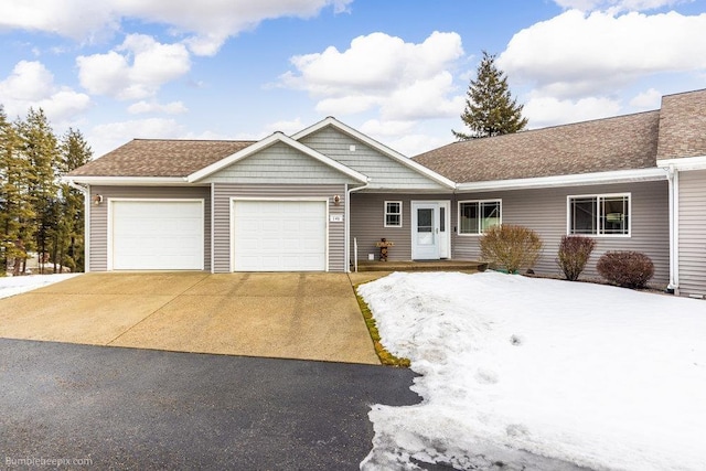 single story home featuring roof with shingles, driveway, and an attached garage