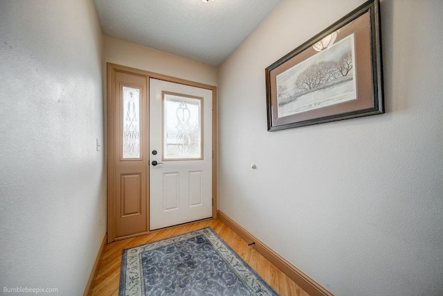 doorway to outside with baseboards and light wood-style floors