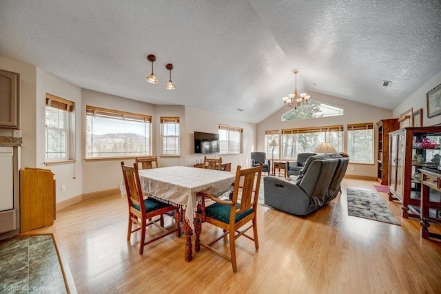 dining room with light wood finished floors, baseboards, an inviting chandelier, vaulted ceiling, and a textured ceiling