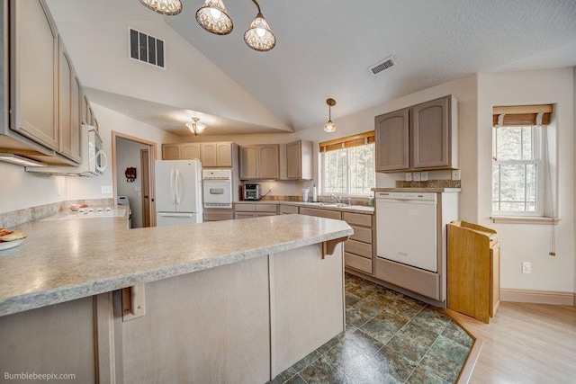 kitchen with white appliances, light countertops, hanging light fixtures, and visible vents