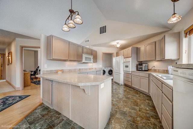 kitchen with white appliances, visible vents, washer and clothes dryer, and light countertops