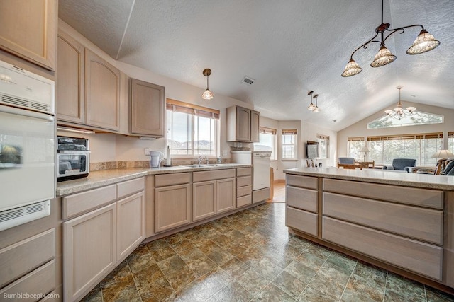 kitchen featuring pendant lighting, light countertops, a sink, and light brown cabinetry