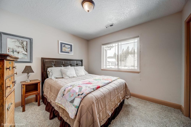 bedroom featuring light carpet, a textured ceiling, visible vents, and baseboards