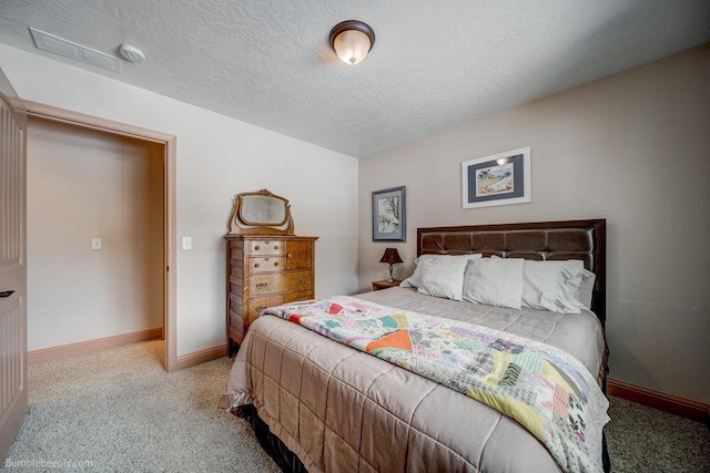 bedroom featuring light carpet, baseboards, and a textured ceiling