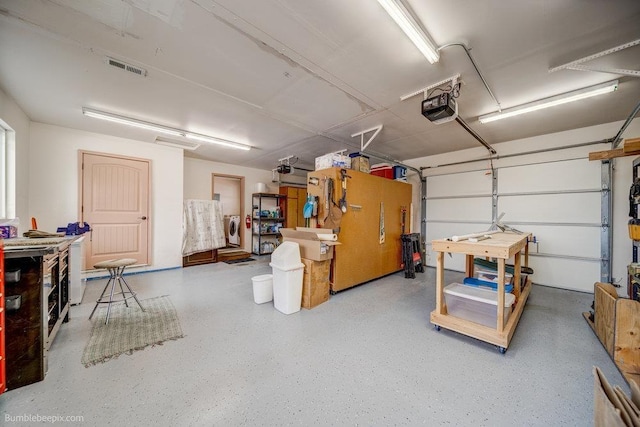 garage with a garage door opener, washer / clothes dryer, and visible vents