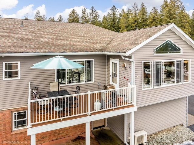 rear view of house featuring ac unit, a shingled roof, and a wooden deck