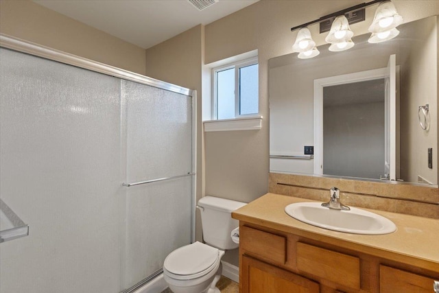 bathroom featuring a shower with door, vanity, and toilet