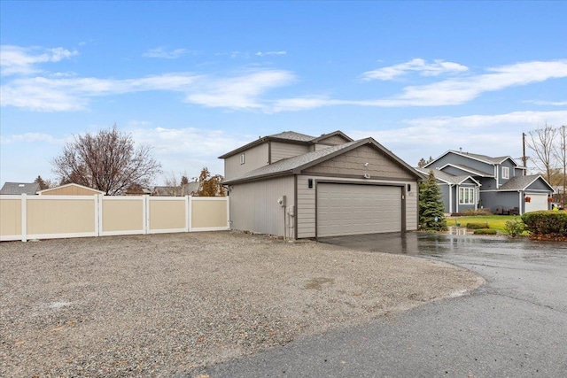 view of front facade featuring fence, driveway, and an attached garage