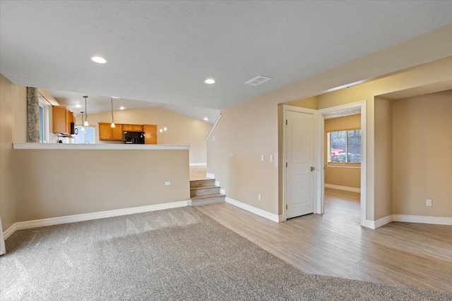 unfurnished living room with baseboards, stairs, visible vents, and a textured ceiling