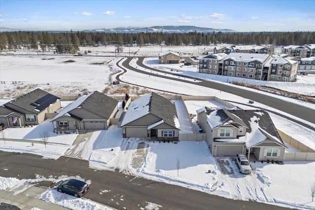 snowy aerial view with a residential view and a mountain view