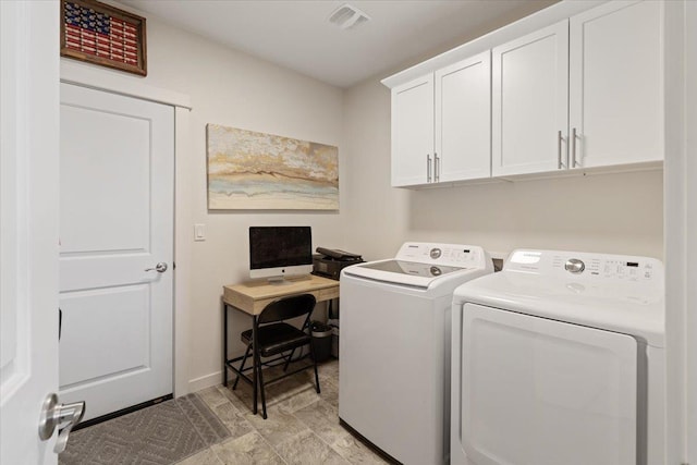 clothes washing area with visible vents, cabinet space, and washer and dryer