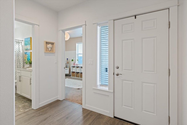 foyer entrance featuring light wood-type flooring and baseboards