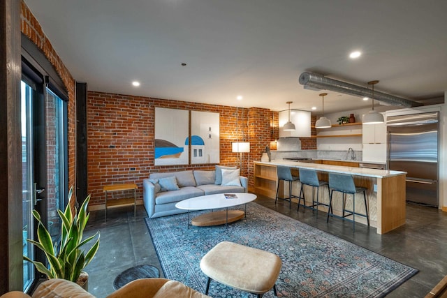 living area featuring brick wall and recessed lighting