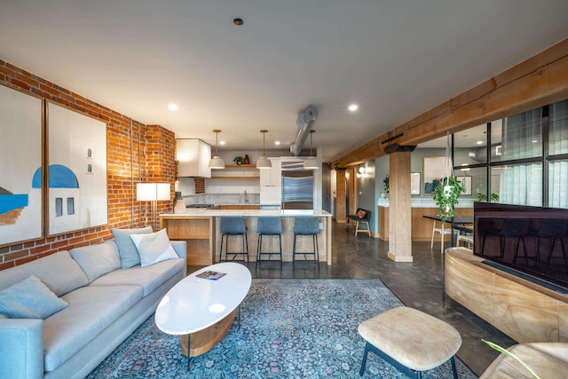 living area featuring concrete flooring, recessed lighting, and brick wall