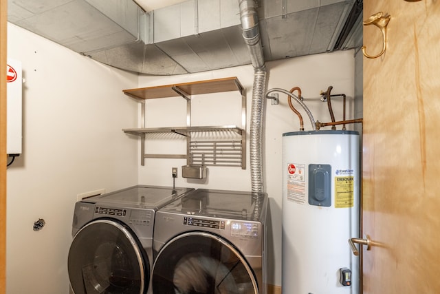 clothes washing area with water heater, laundry area, and washing machine and dryer