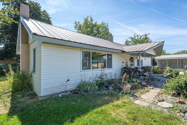 view of front of property with a chimney and metal roof