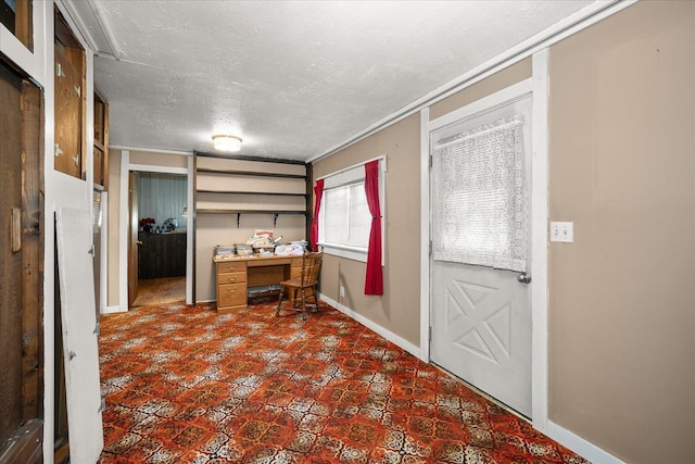 unfurnished office with a textured ceiling and baseboards