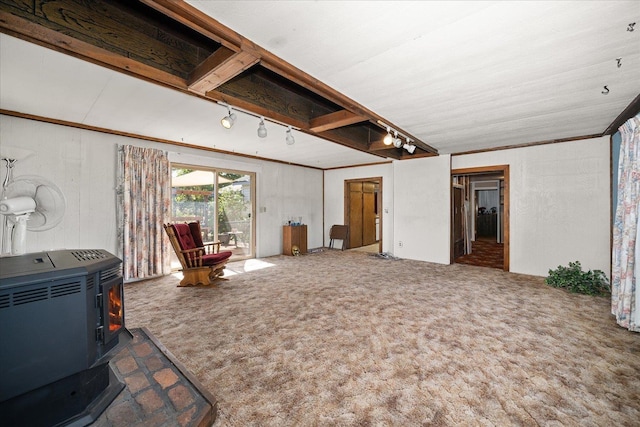 living area featuring crown molding, heating unit, a wood stove, carpet flooring, and track lighting