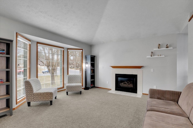 carpeted living area featuring a fireplace, a textured ceiling, and baseboards