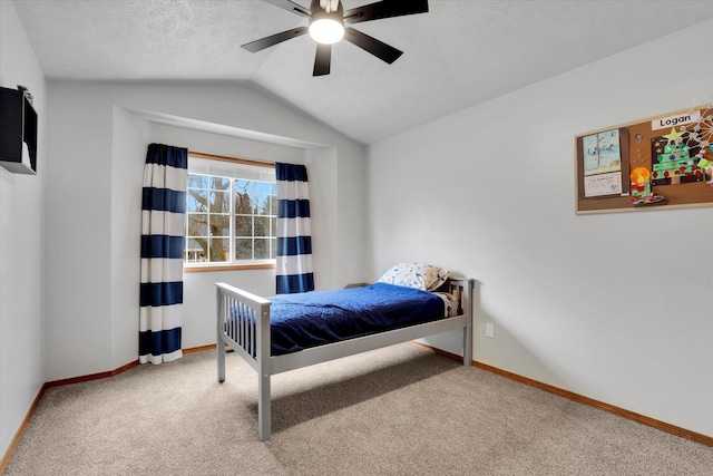 bedroom featuring lofted ceiling, carpet, baseboards, and a textured ceiling