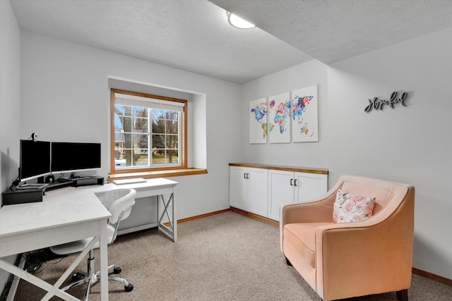 home office with a textured ceiling, baseboards, and light colored carpet