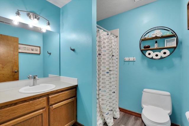 bathroom with visible vents, a shower with shower curtain, toilet, vanity, and wood finished floors