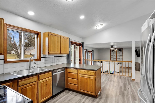 1107 E Chantel Dr, Spokane, WA 99218 - kitchen with stainless steel appliances, a sink, vaulted ceiling, a peninsula, and light wood-style flooring