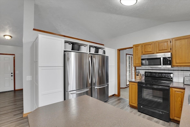 1107 E Chantel Dr, Spokane, WA 99218 - kitchen featuring appliances with stainless steel finishes, lofted ceiling, light wood-style flooring, open shelves, and backsplash