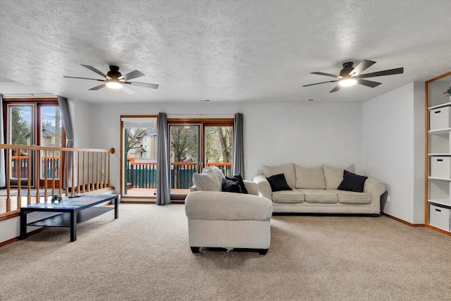 carpeted living area with a wealth of natural light, ceiling fan, a textured ceiling, and baseboards