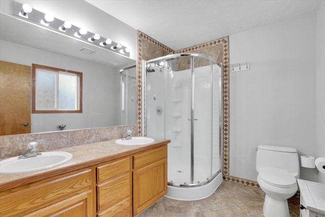 full bath featuring toilet, a shower stall, double vanity, and a sink